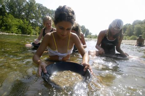 Dans les rivières des Cévennes, certains vacanciers se transforment en véritables chercheurs d'or. L'initiative a été lancée, il y a cinq ans, par le centre de formation à l'orpaillage Oreval, en partenariat avec le camping du Chercheur d'or à Cardet. | AFP/DOMINIQUE FAGET